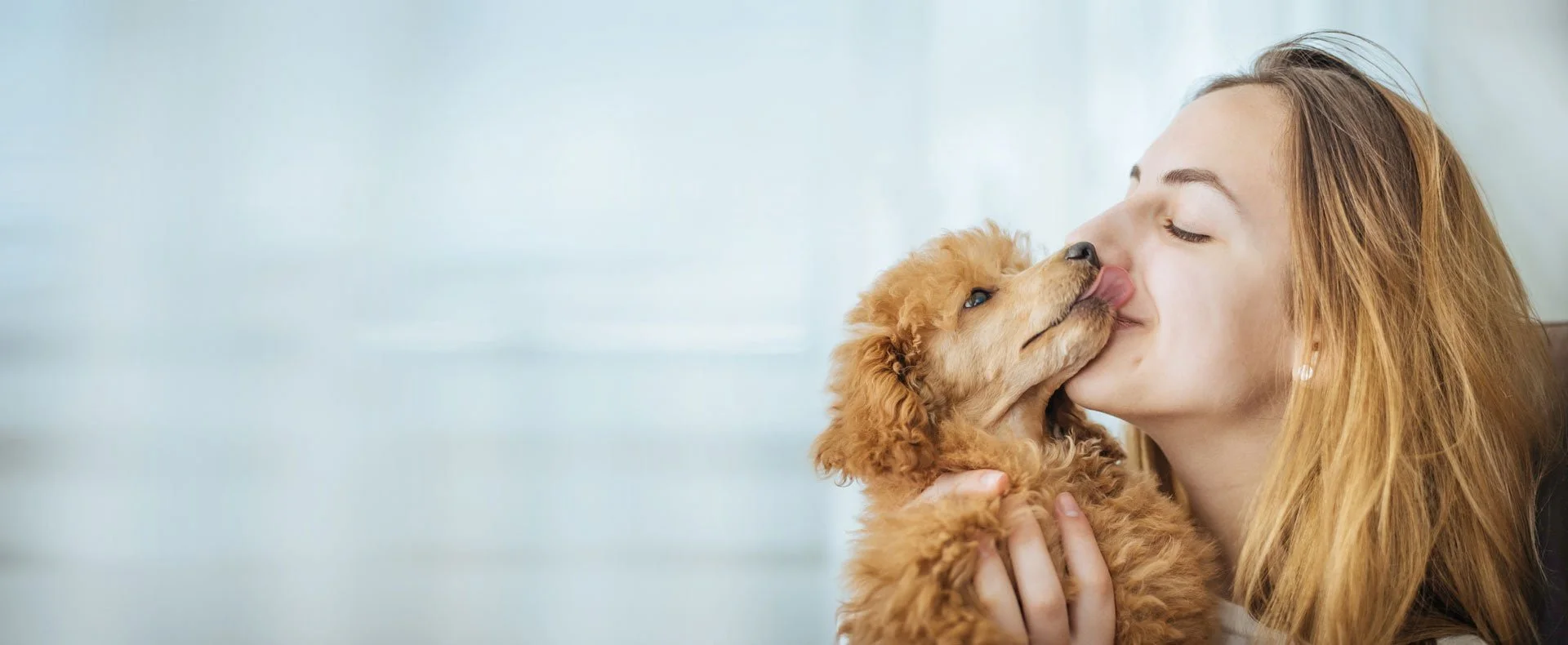 blonde woman kissing her doggy